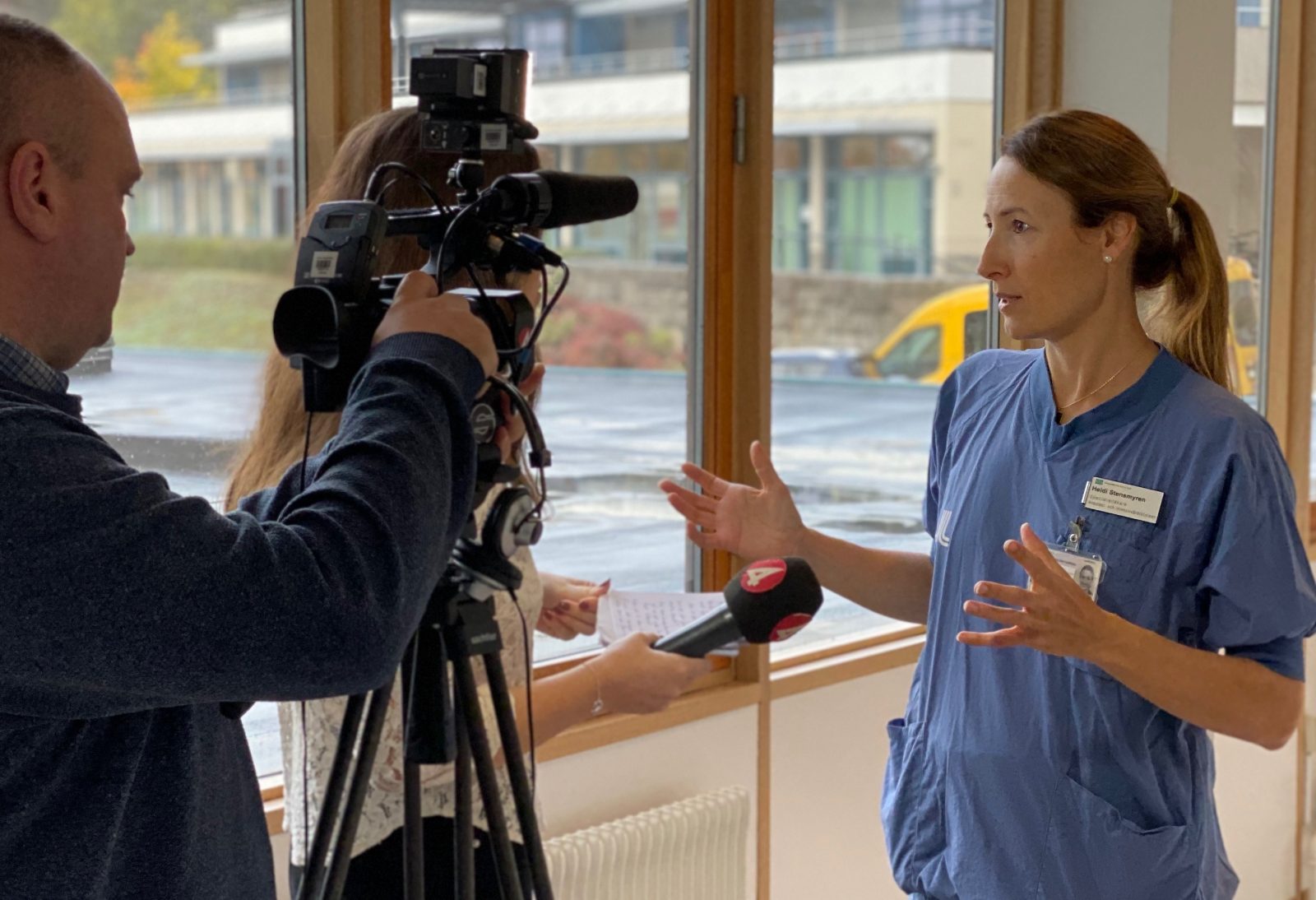 Heidi Stensmyren pratar med journalist framför en kamera